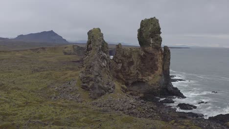 flying around londrangar, a pair of rock pillars on the coast of snaefellsnes in iceland