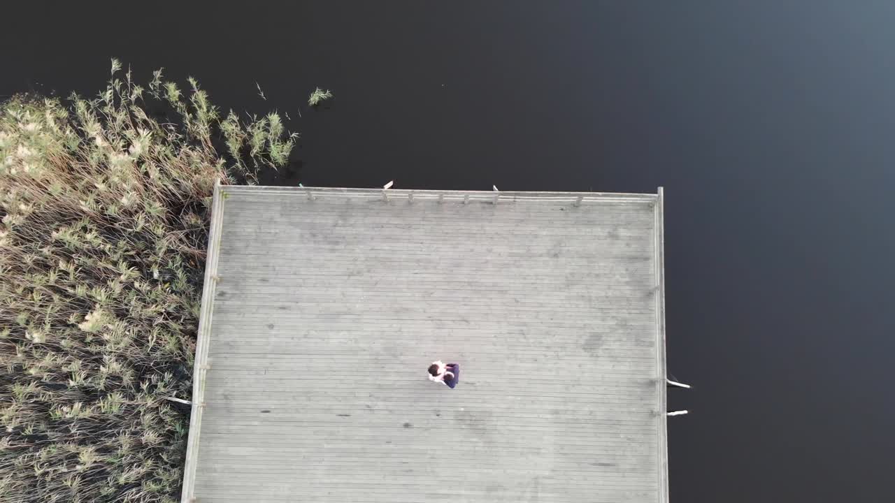 목조 부두에 포옹 하는 커플. 공중 하향식 상승