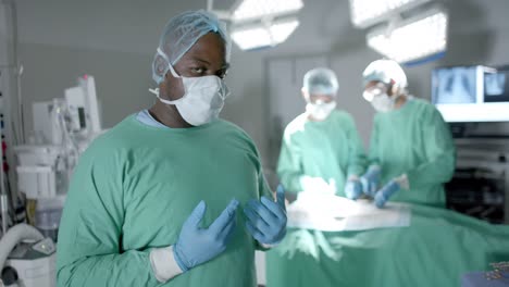 Portrait-of-diverse-surgeons-with-face-masks-during-surgery-in-operating-room-in-slow-motion