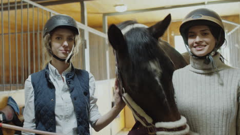 two women and a horse in a stable