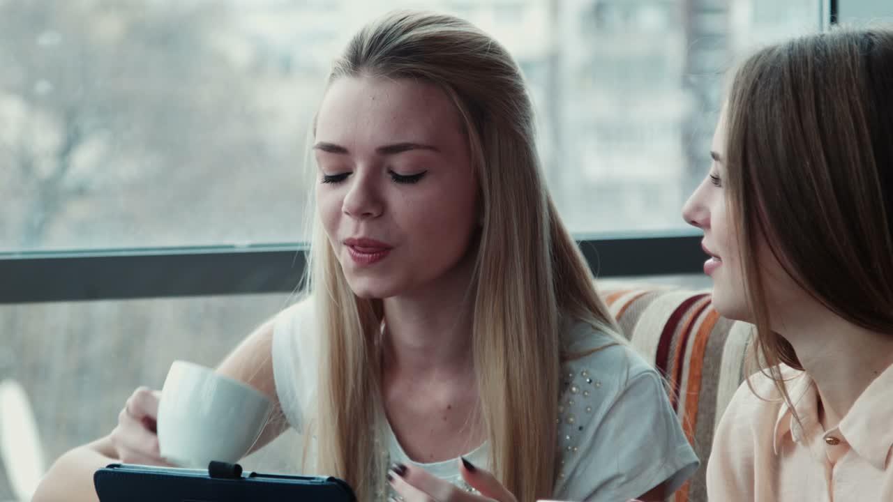 Two Girlfriends Drink Coffee