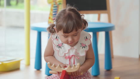 Portrait-of-Happy-Smiling-Little-Girl-Riding-Rocking-Deer-at-Playroom-in-Slow-motion