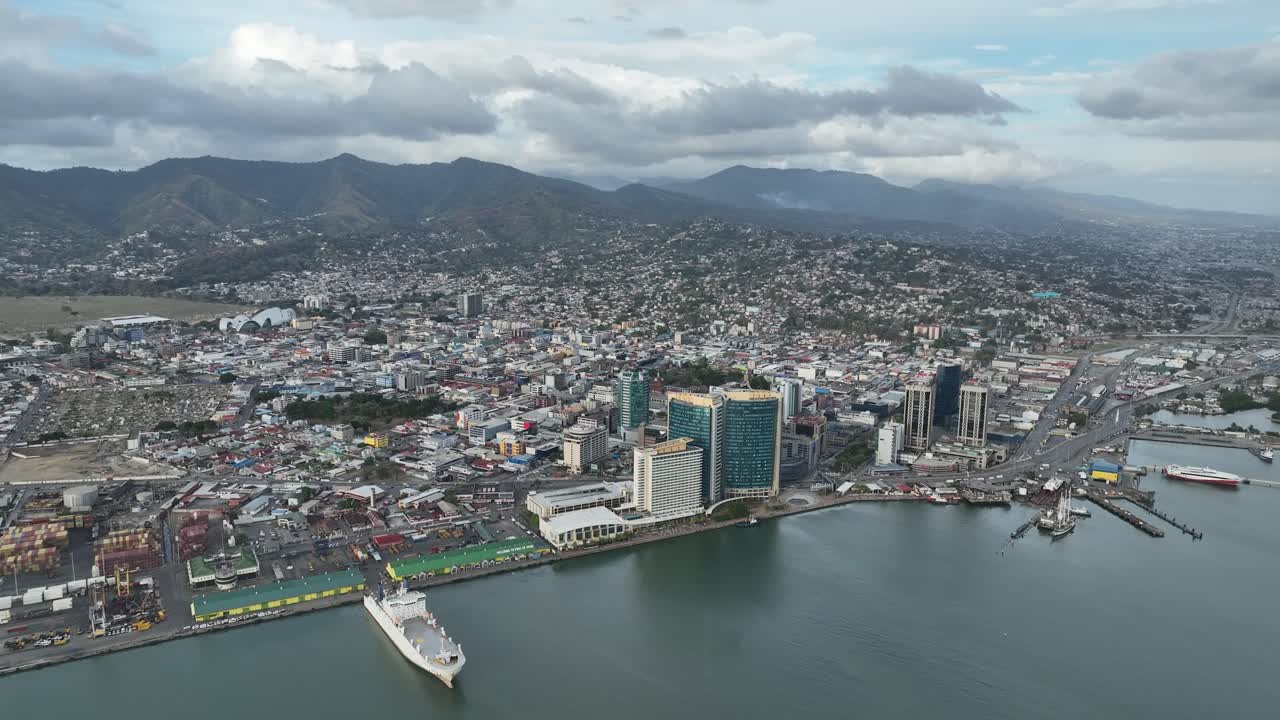 포트 오브 스페인의 스카이라인을 물에서 찍은 사진. 앞면에는 보트가 있습니다.