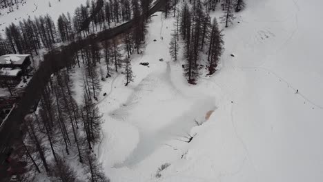 aerial view of a frozen lake in a mountain valley in valle d'aosta, in the italian alps, in winter