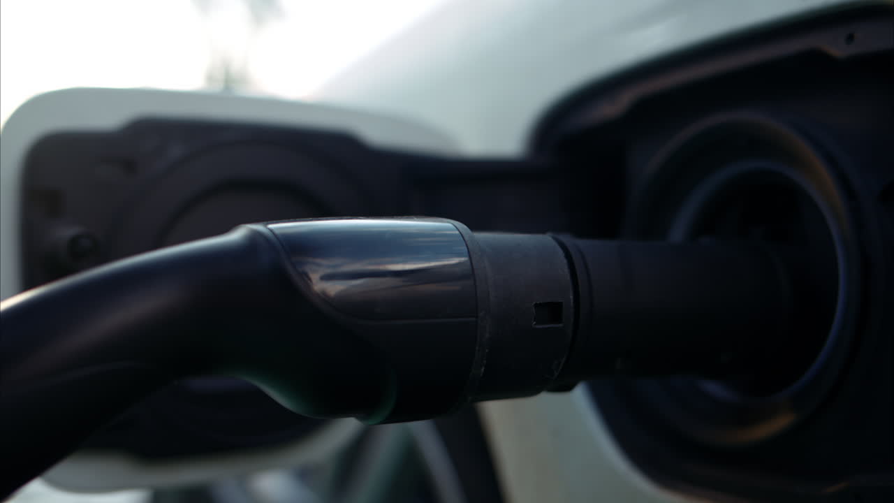 Electric car charger close up, blurred city view on the background