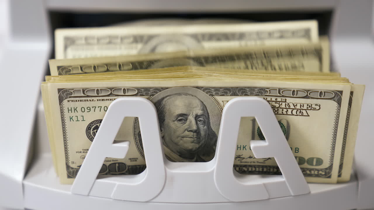 Counting process of dollar banknotes. Automated financial operations. Currency counting machine counts hundred dollar bills. Banking and commercial activity. Close-up.