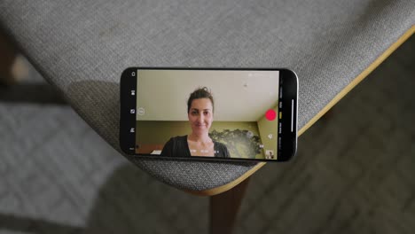 talking to female friend via videocall on smartphone whilst tapping icons on screen