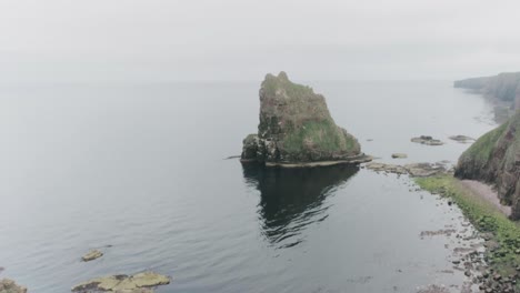 slow drone reveal of the stacks of duncansby in misty weather along the scotland north coast 500 route at john o'groats