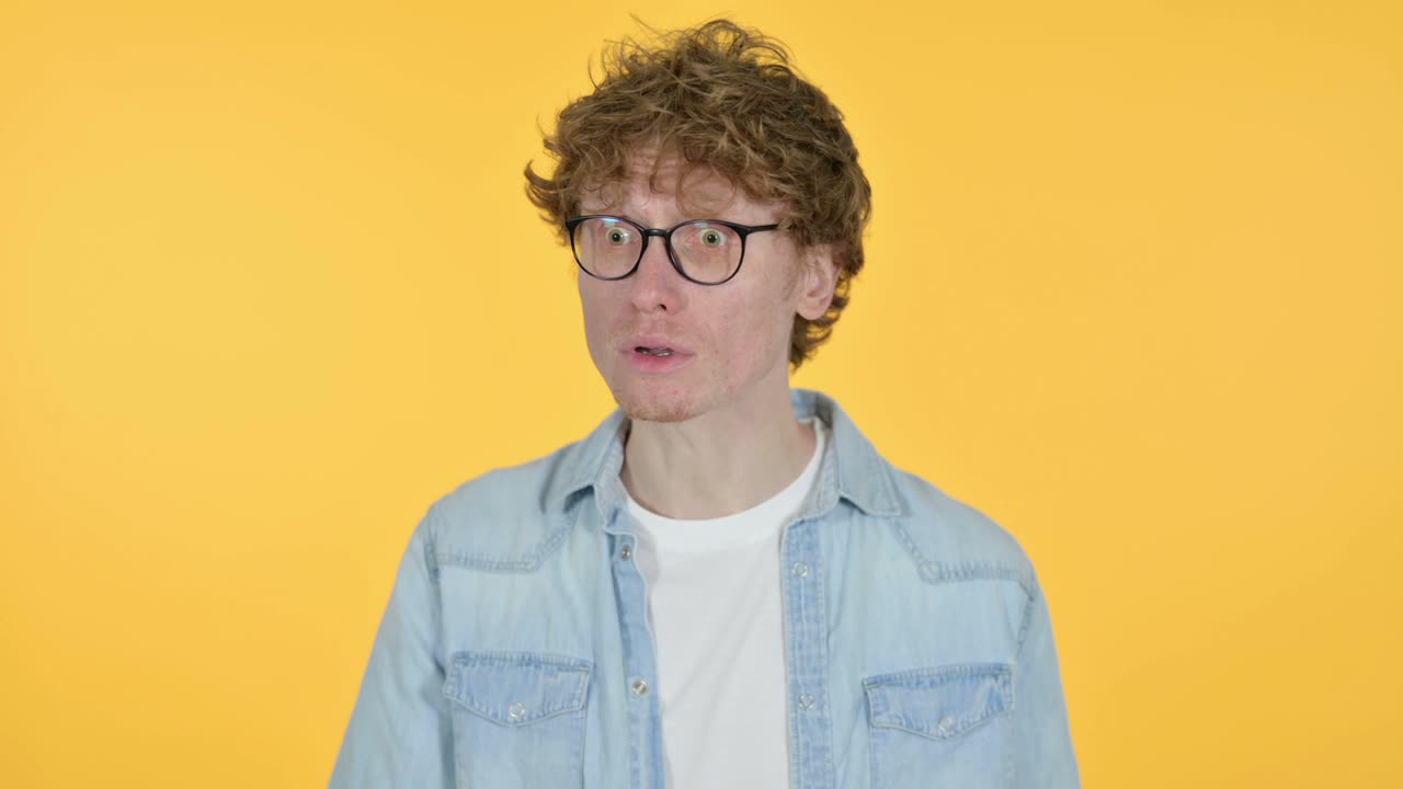 joven pelirrojo bostezando, fondo amarillo