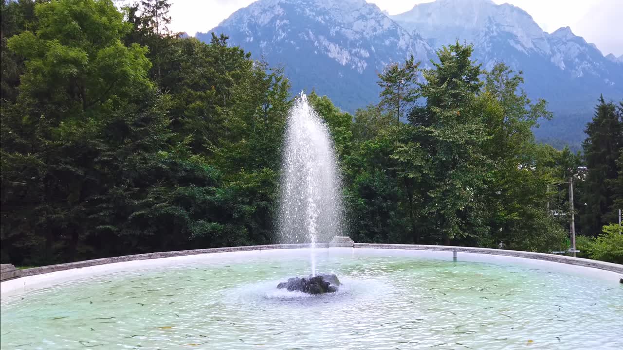 Fountain among trees and mountains in Brasov