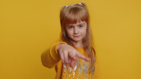 una niña con un suéter amarillo apuntando a la cámara