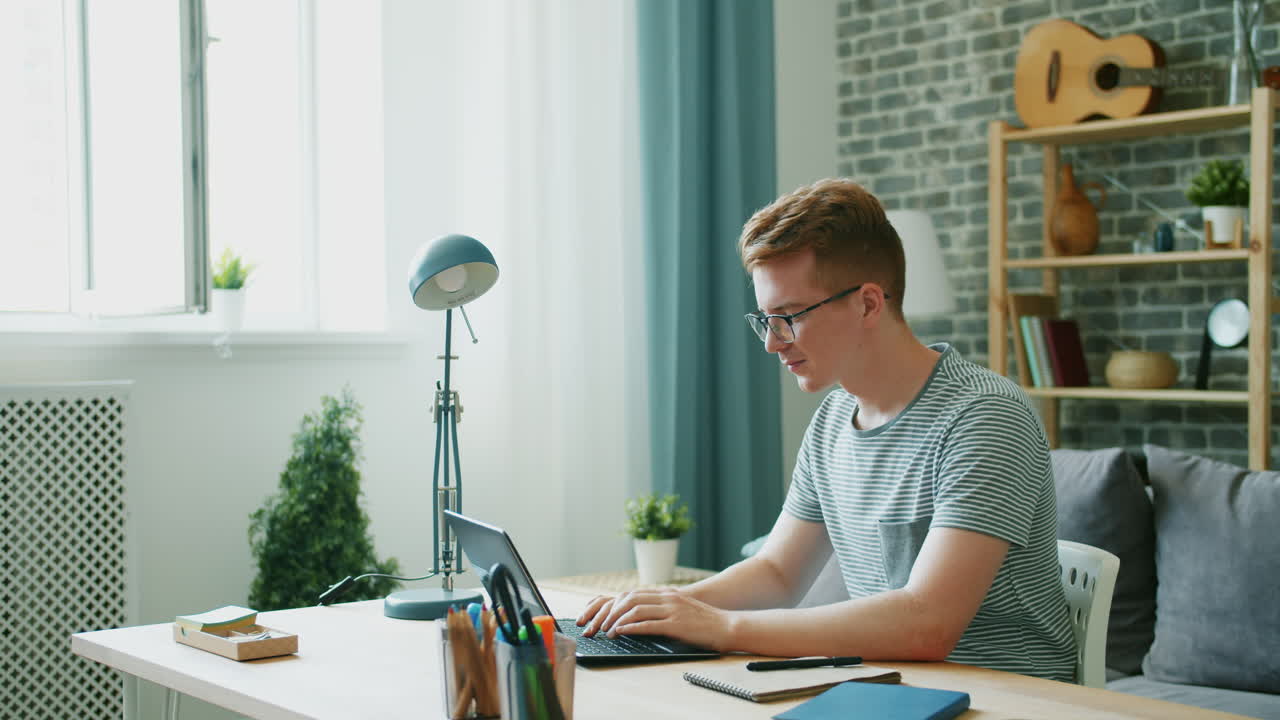 노트북에 가정에서 일하는 젊은 남자