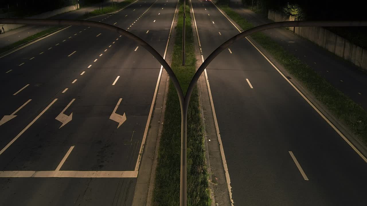 A dynamic nighttime timelapse captures the vibrant streaks of car lights weaving through a dual carriageway, illustrating urban motion and connectivity