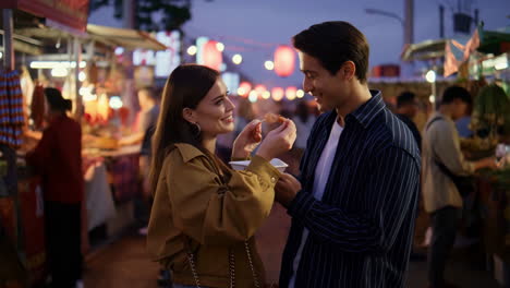 couple enjoying street food at a night market
