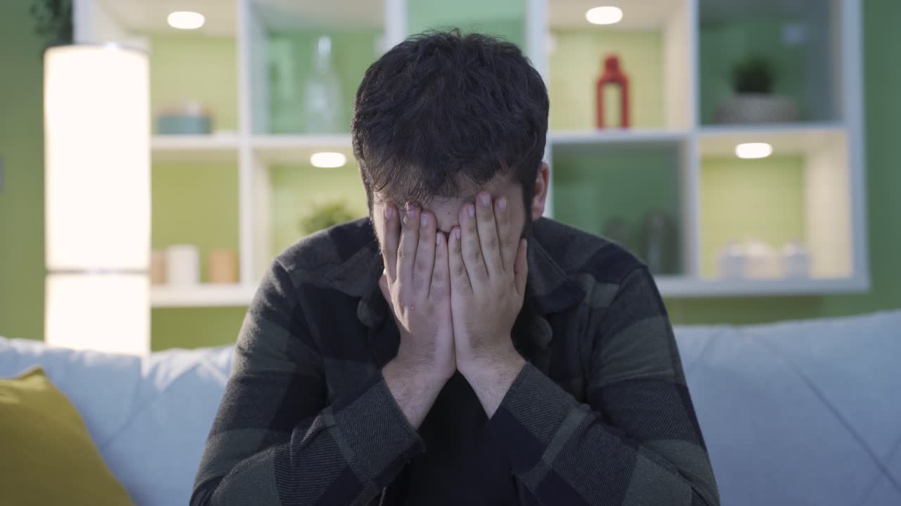 우울증에 걸린 남자는 집에서 질식하고, 사려 깊고, 걱정이 있습니다.