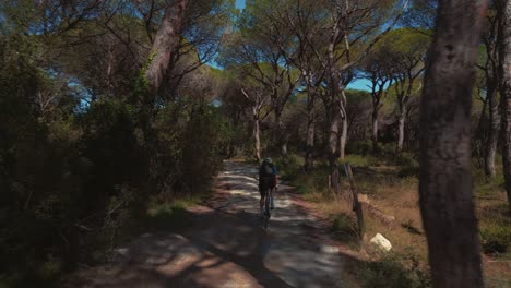 un joven deportista en bicicleta con una bicicleta de carreras en un bosque