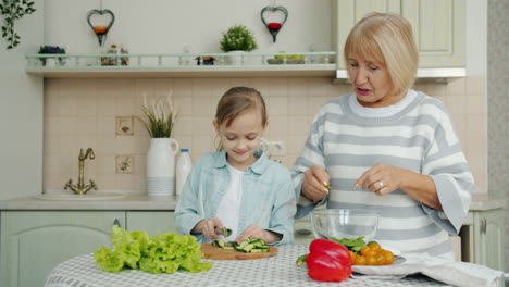 grandmother and granddaughter preparing salad together