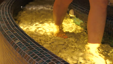 woman walking in hydrotherapy bath in wellness