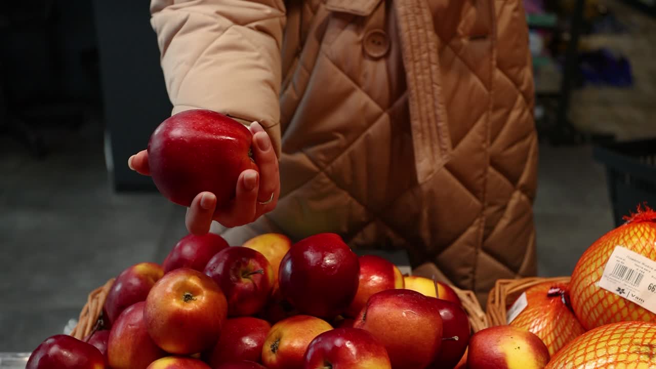 Woman buying apples at a grocery store