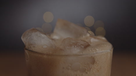 Studio-product-shot-of-cold-coke-pouring-in-to-glass-with-ice