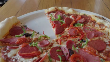 una deliciosa pizza con pepperoni, salchichas, tomates y pimientos verdes
