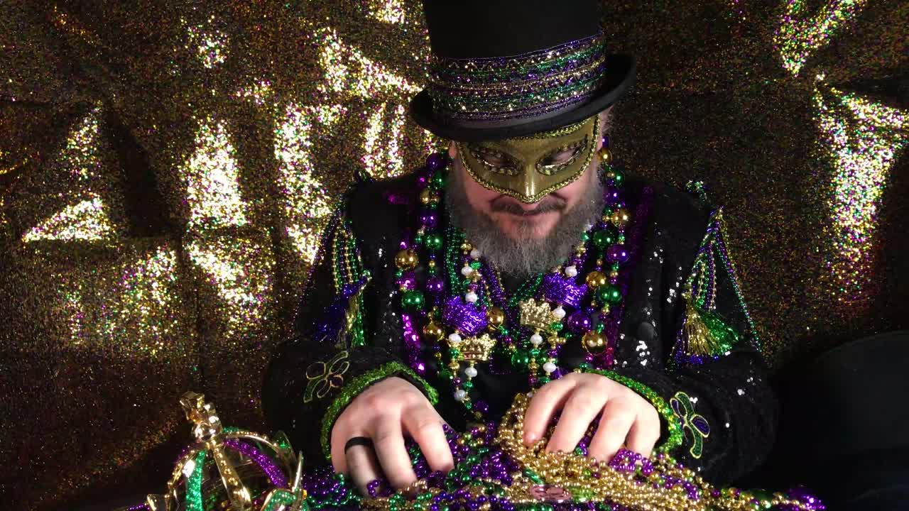 feliz mardi gras hombre disfrazado con sombrero de copa sosteniendo un montón de cuentas