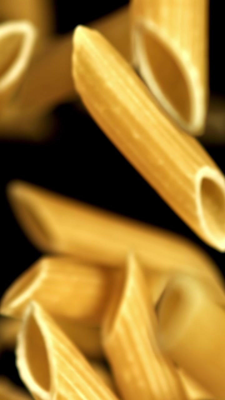 Penne dorate che cadono al rallentatore