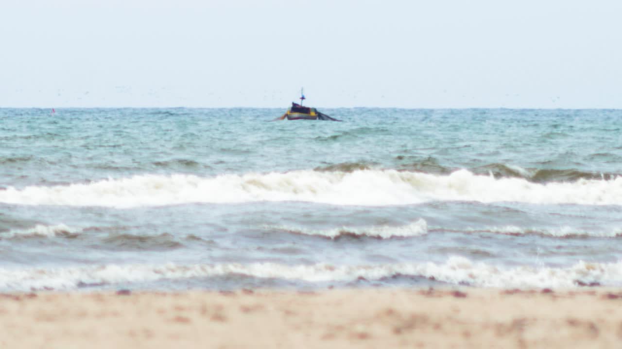 작은 목조 해안 어선은 리파자 근처의 발트해, 흐린 날, 폭염, 전경의 하얀 모래, 낮은 각도의 중간 거리 샷