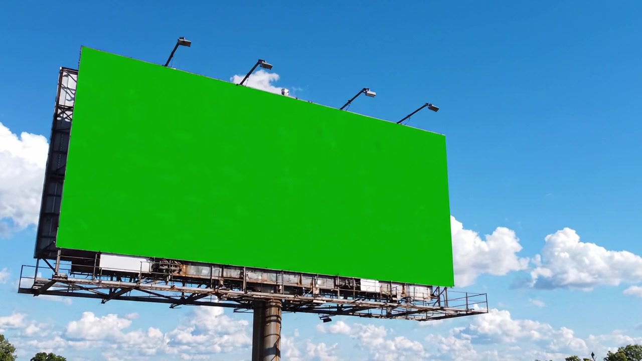 Et levende grønt billboard mod en klar blå himmel med bløde hvide skyer, perfekt til reklame eller kreativ udstilling i udendørs omgivelser