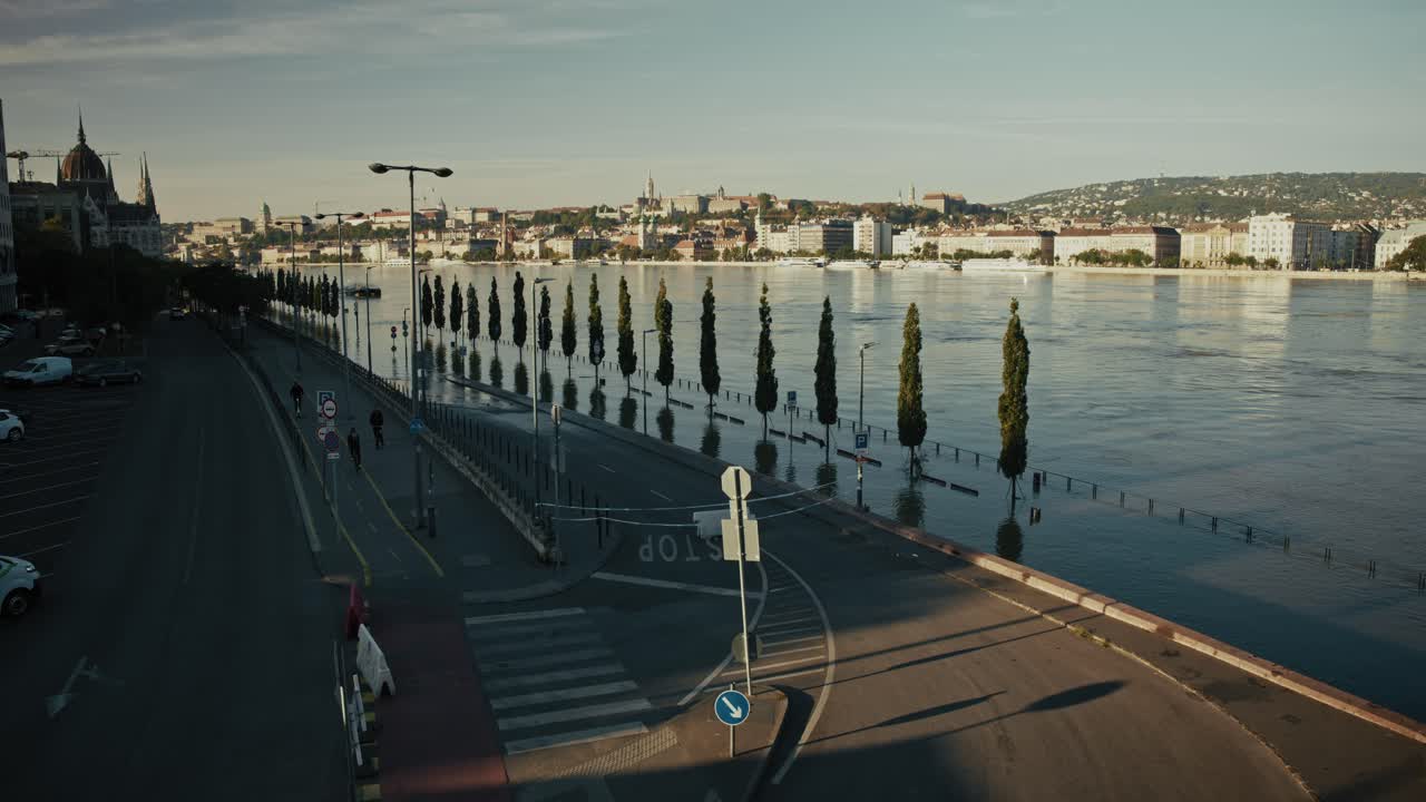 Flooded road alongside Danube river, trees and signs barely visible above water