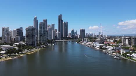 Vista-Aérea-Viajando-A-Lo-Largo-Del-Río-Nerang-Hacia-El-Imponente-Horizonte-De-La-Ciudad-Del-Icónico-Suburbio-De-Gold-Coast-Surfers-Paradise