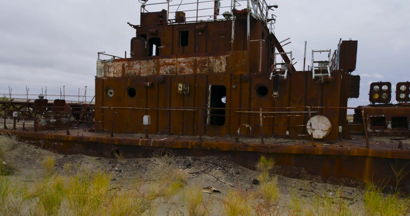 An abandoned rusted ship lies stranded on the dry Aral Sea seabed.