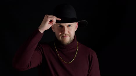 a man posing in a black hat and gold chain