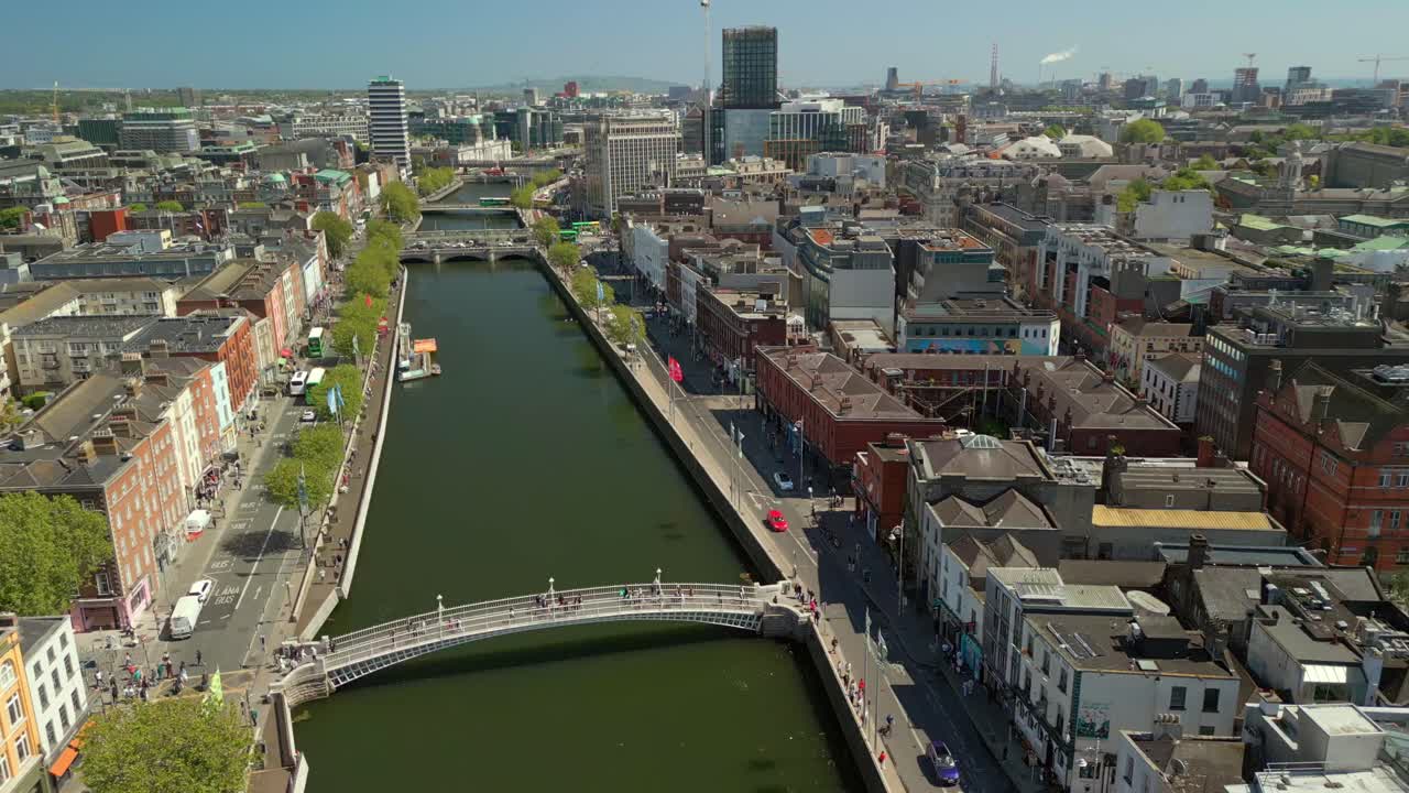 Slow travelling wide aerial video of the River Liffey, various bridges and Dublin City Centre in Dublin, Ireland on a bright and sunny day. Filmed in 4K, 60FPS and with Rec709 color.