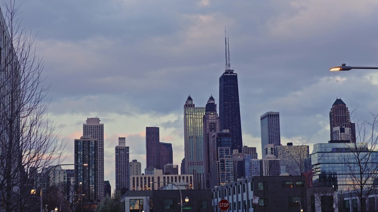 Cielo nuvoloso su Chicago con grattacieli e paesaggio urbano alla luce della sera, che mostra attività cittadina e traffico.