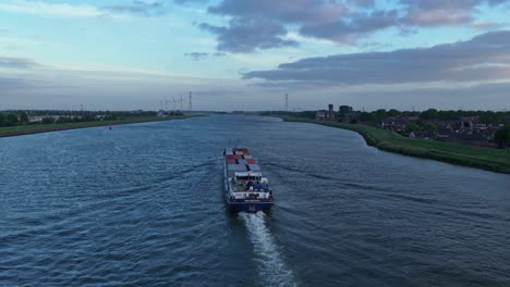 following aerial movement behind the progresso dordrecht cargo ship cruising alone on the wide river channel, zuid-holland, netherlands
