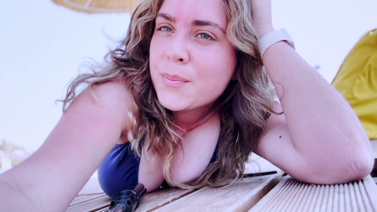 Young Woman Talking to Camera on a Sunny Beach Vacation