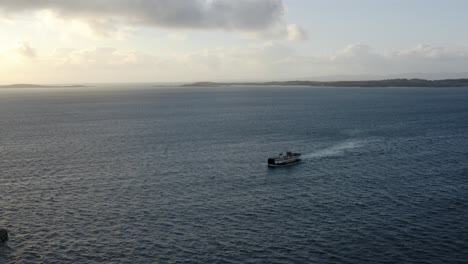 Aéreo---Ferry-Que-Llega-Al-Amanecer-A-La-Isla-De-Gigha,-Kintyre,-Escocia,-Adelante