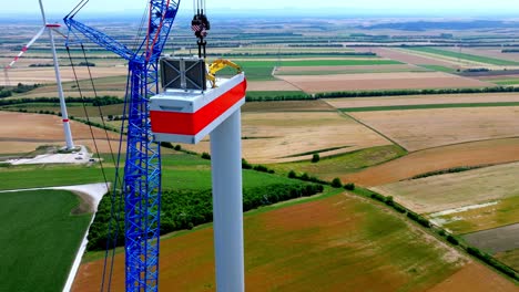 construction of wind turbine head in a wind farm in austria - aerial drone shot