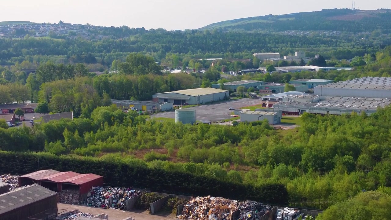 Industrial Landscape near Recycling Center Below with Various Warehouses Surrounded by Natural Landscape with Trees. Aerial Drone Industry Clip.