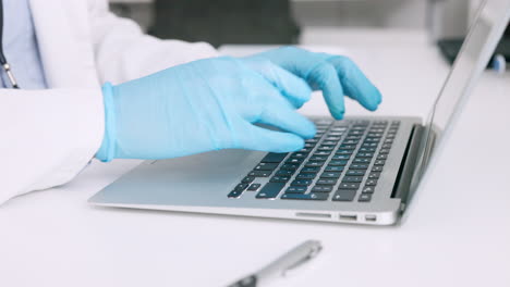 de las manos de un científico con guantes quirúrgicos