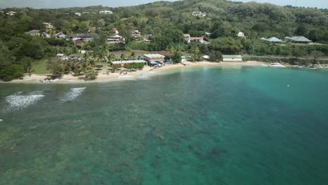 ascending aerial of waves breaking on the shallow reef of mt irvine bay located on the caribbean island of tobago