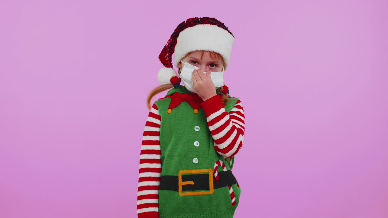 Dívka, vánoční Santa Claus Elf v obličejové masce OOP pro ochranu před koronavirem v karanténě během uzávěry.