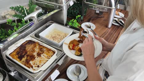 woman serving food at a buffet lunch