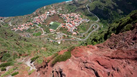 Vista-Sobre-Un-Paisaje-Rojo,-Revelando-Lentamente-La-Costa-De-La-Gomera-Con-El-Volcán-Teide-Al-Fondo,-España