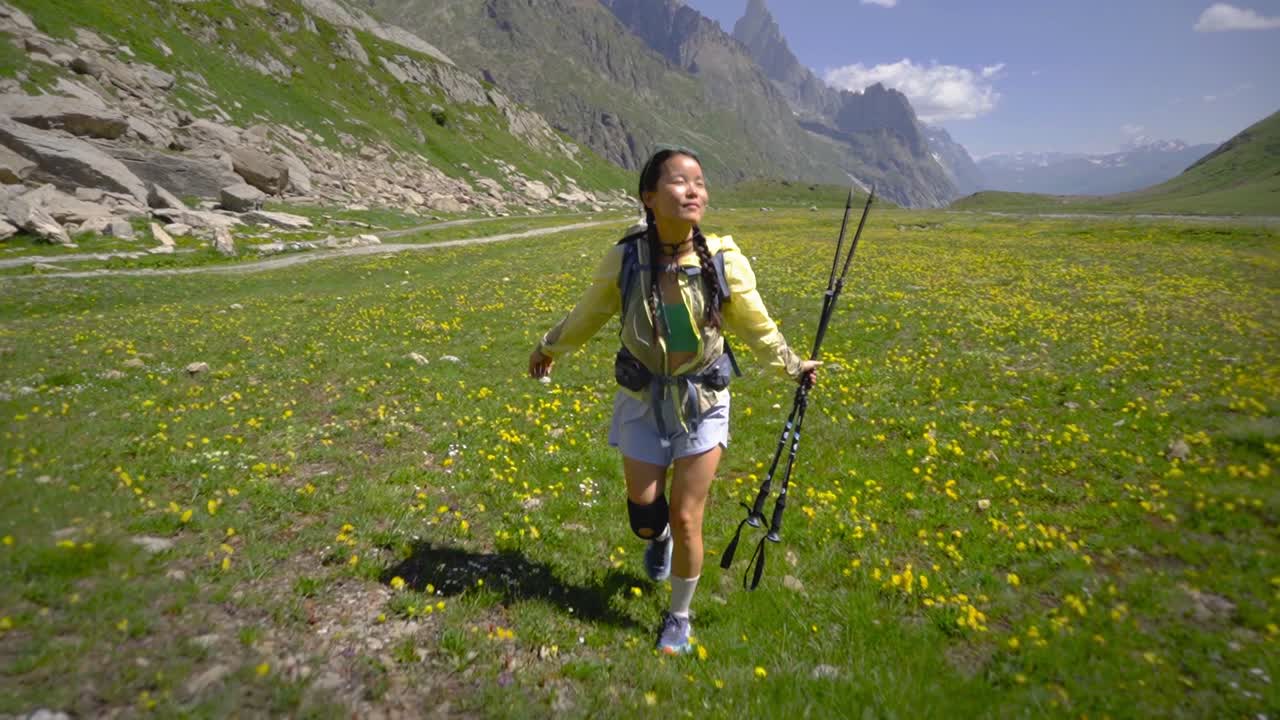 mujer china libre caminando en cámara lenta en el campo de flores montañosas