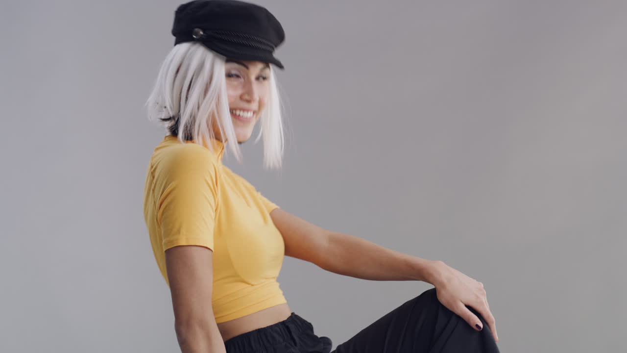 стильная женщина в желтом топе и шляпе.