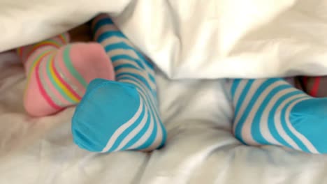 los pies de una familia en la cama