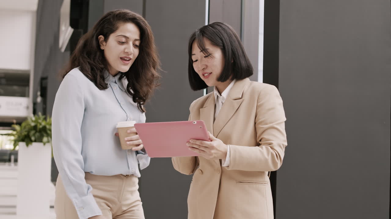 두 명의 다양한 사업가 여성이 사무실에서 만납니다.