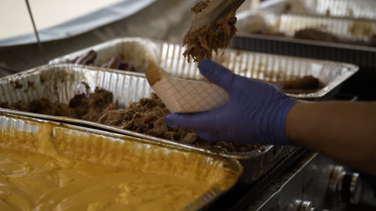 deliciosa comida callejera - carne de cerdo con salsa de queso colocada en una bandeja de papel